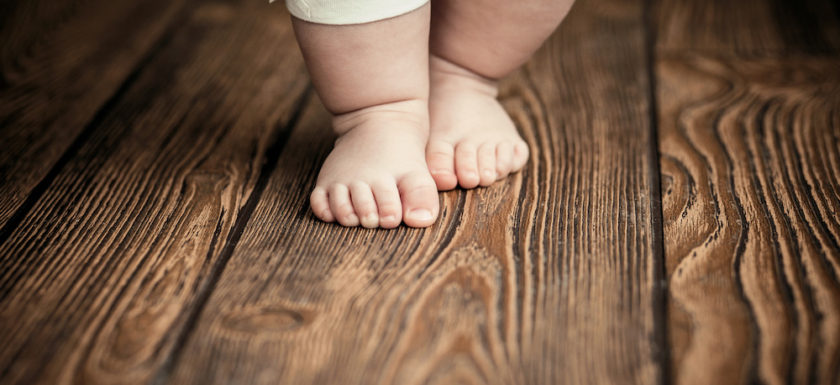 Baby feet doing the first steps. Baby's first steps.